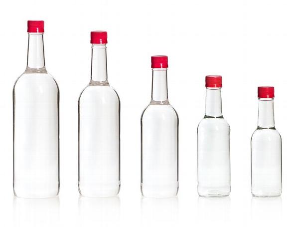 5 different sized glass bottles with red caps