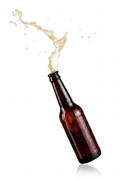 Open beer bottle with beer flying out